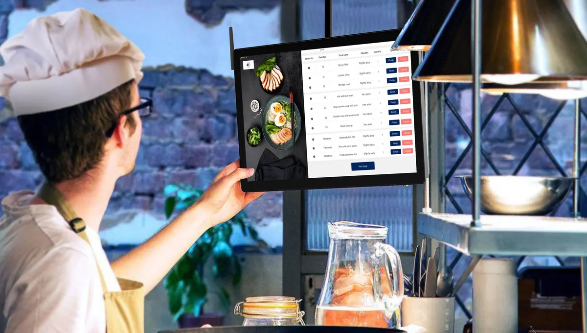 Chef checking incoming orders on a kitchen tablet during service
